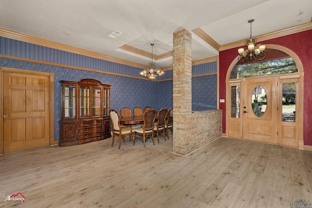 interior space with wood finished floors, a notable chandelier, decorative columns, and wallpapered walls