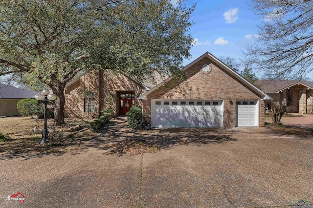 view of front of house featuring driveway and brick siding