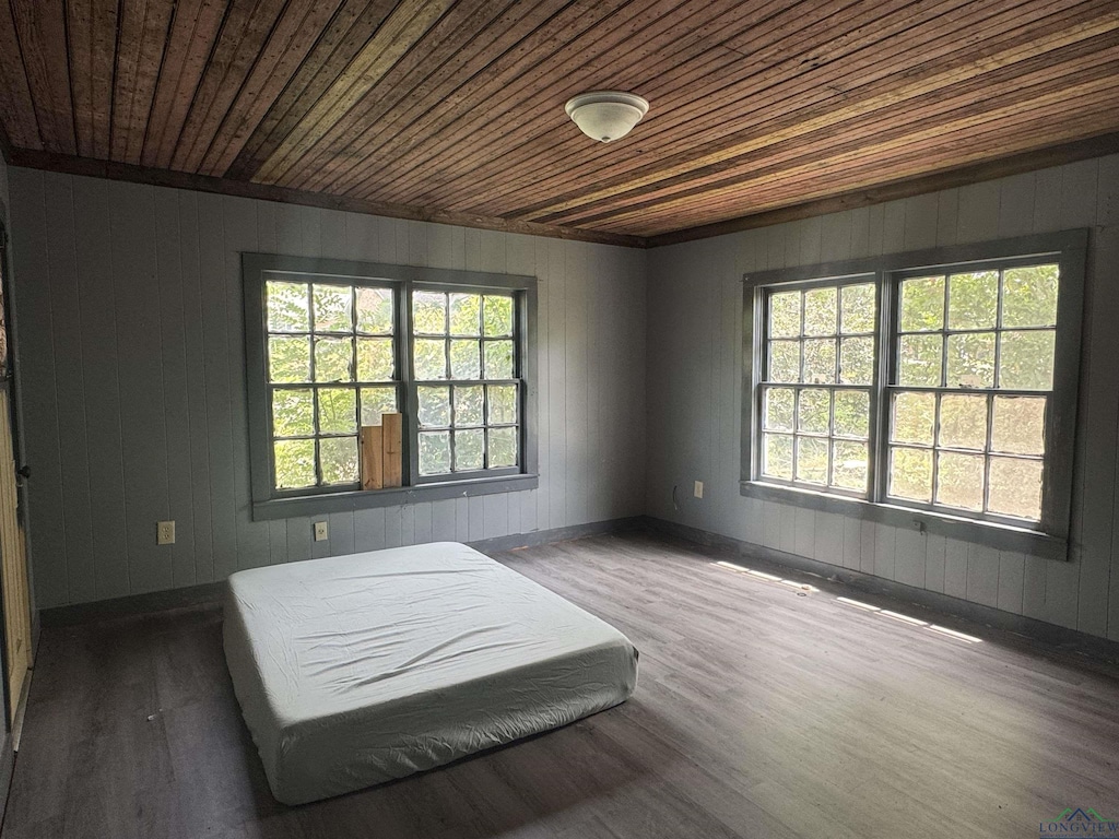 bedroom featuring wood walls, wood finished floors, and wooden ceiling