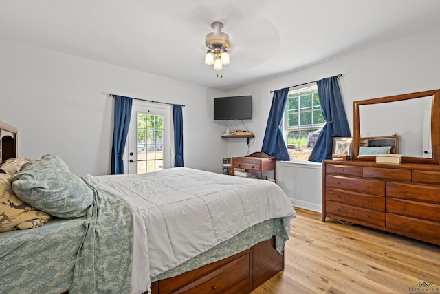 bedroom featuring light wood-type flooring, access to outside, multiple windows, and ceiling fan