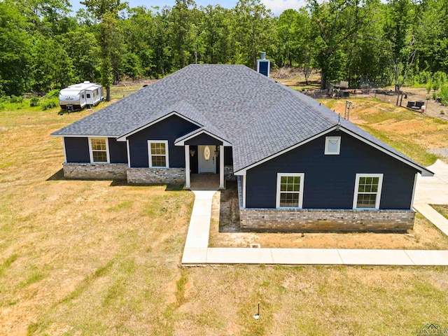 view of front of property with a front yard, brick siding, and roof with shingles