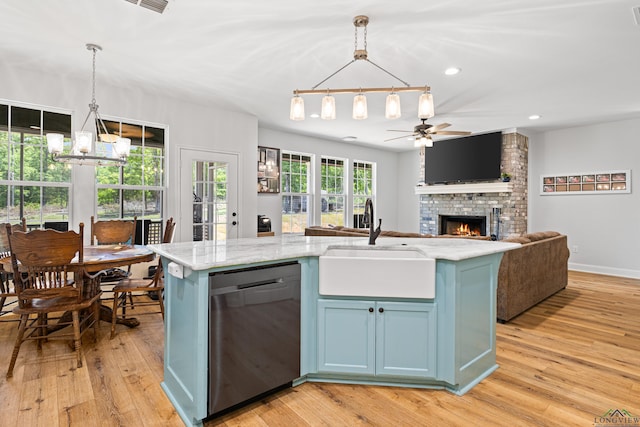 kitchen with black dishwasher, an island with sink, open floor plan, and pendant lighting