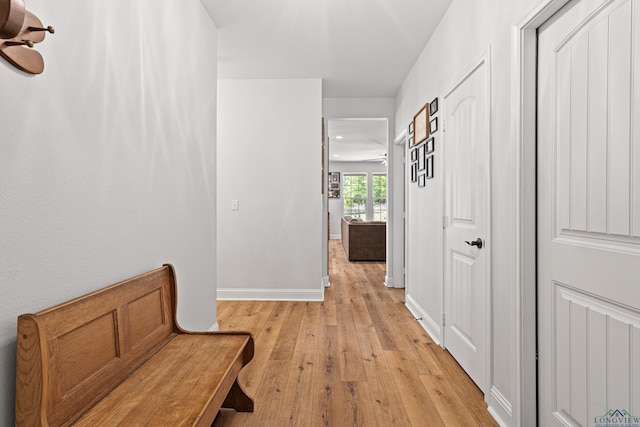 hallway featuring light wood-style floors and baseboards