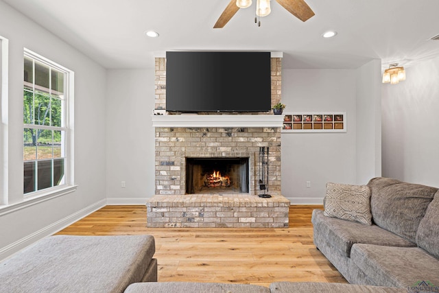 living room featuring recessed lighting, a ceiling fan, a brick fireplace, wood finished floors, and baseboards