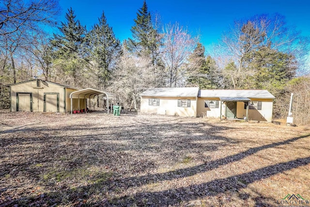 ranch-style house featuring an outbuilding and a carport