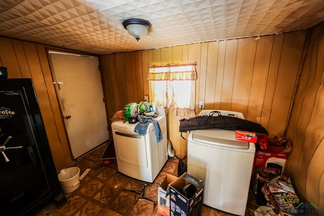 laundry room with washer and dryer and wooden walls