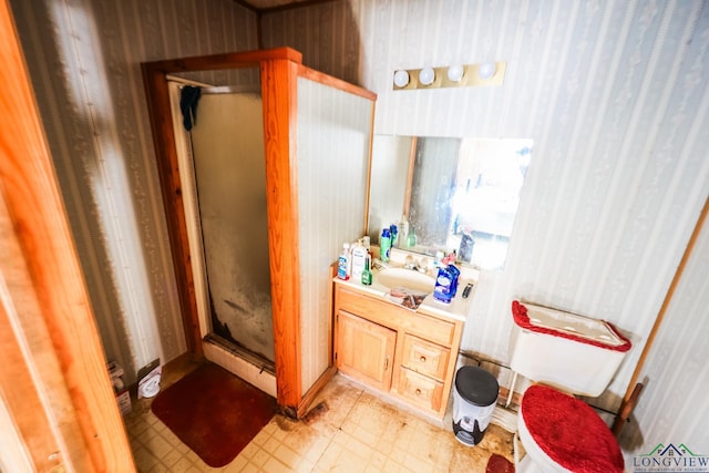 bathroom with vanity, a shower with shower door, and toilet