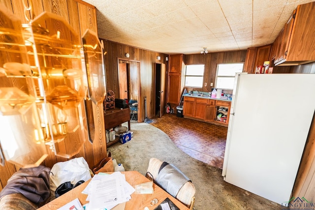 kitchen featuring white refrigerator and wooden walls