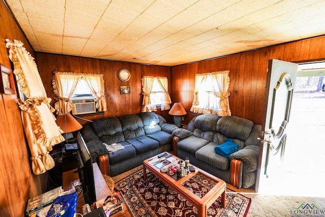 living room featuring cooling unit, wood walls, and carpet floors