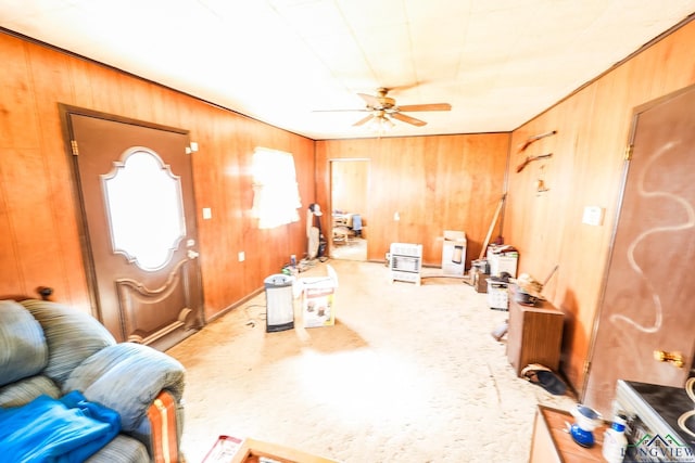 interior space featuring ceiling fan and wood walls