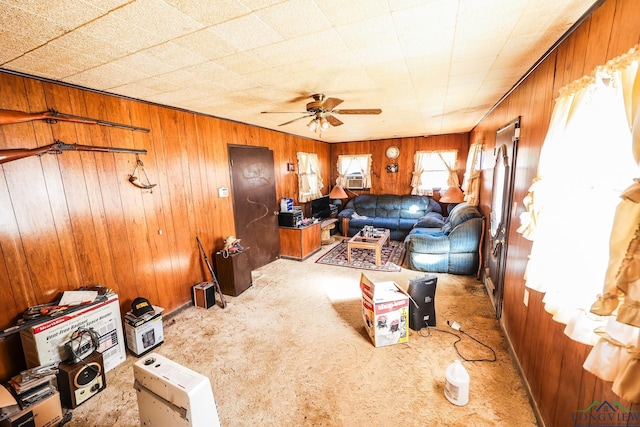 living room featuring light colored carpet, ceiling fan, and wooden walls