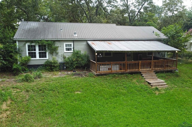 rear view of property with a lawn and central AC