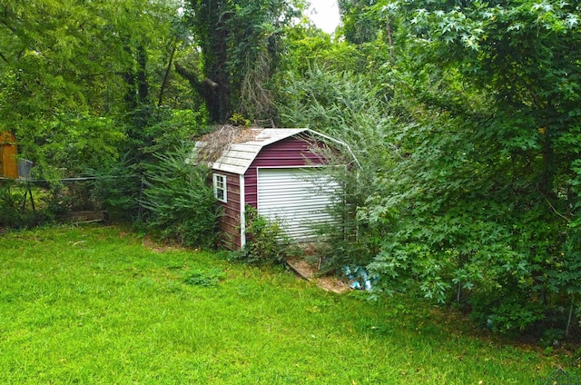 view of outdoor structure featuring a lawn and a garage