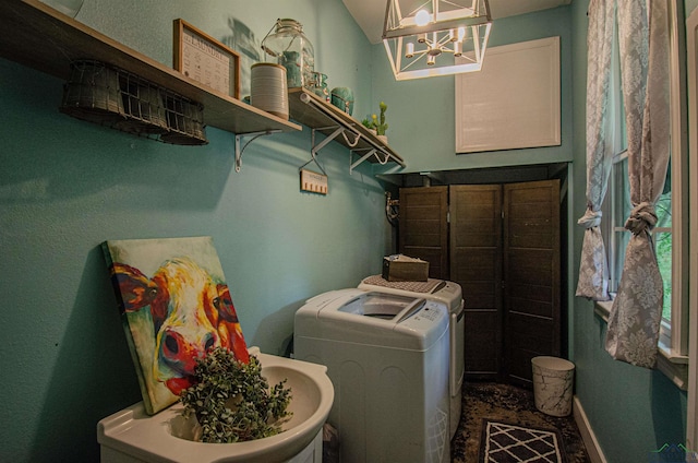 clothes washing area with a chandelier and independent washer and dryer