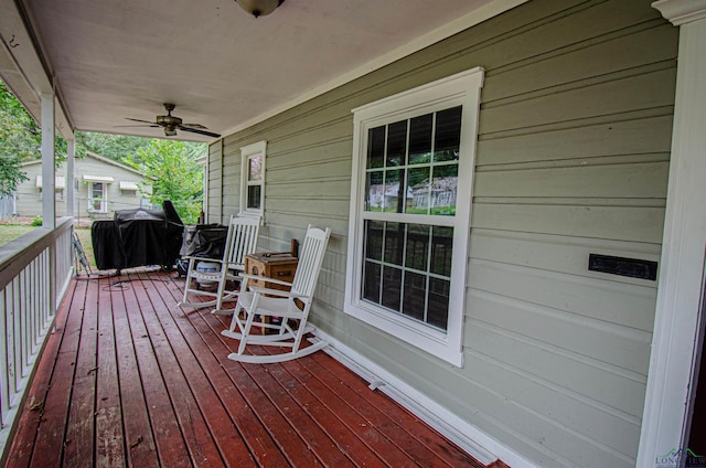 wooden terrace with grilling area, ceiling fan, and covered porch