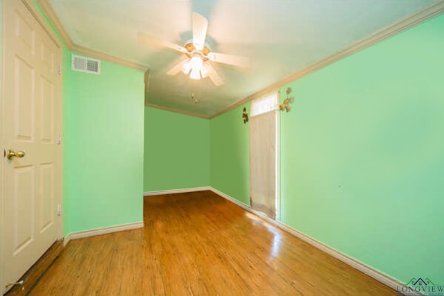 spare room featuring ceiling fan, light wood-type flooring, and ornamental molding