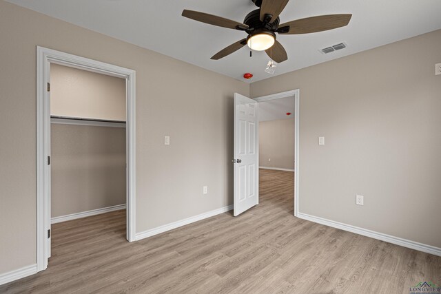 unfurnished bedroom with light wood-style floors, visible vents, a closet, and baseboards