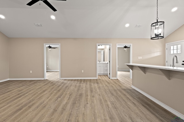 unfurnished living room featuring recessed lighting, baseboards, light wood-style flooring, and vaulted ceiling