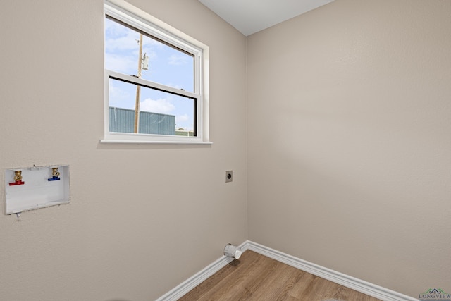 laundry room with electric dryer hookup, washer hookup, light wood finished floors, baseboards, and laundry area