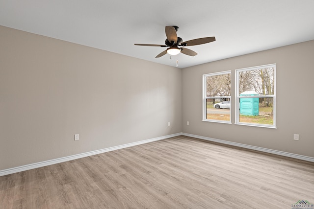 empty room with a ceiling fan, baseboards, and light wood-type flooring