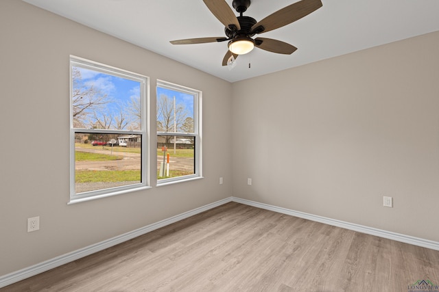 spare room with light wood-style flooring, baseboards, and ceiling fan