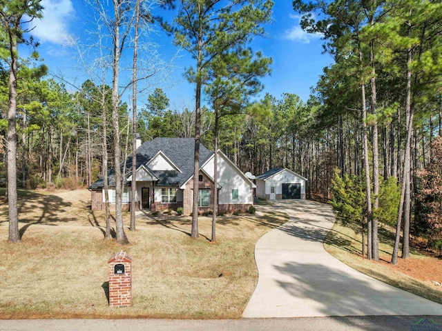 view of front of house with a garage, a front lawn, and an outdoor structure