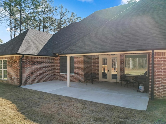 rear view of property featuring a patio area, a yard, and french doors