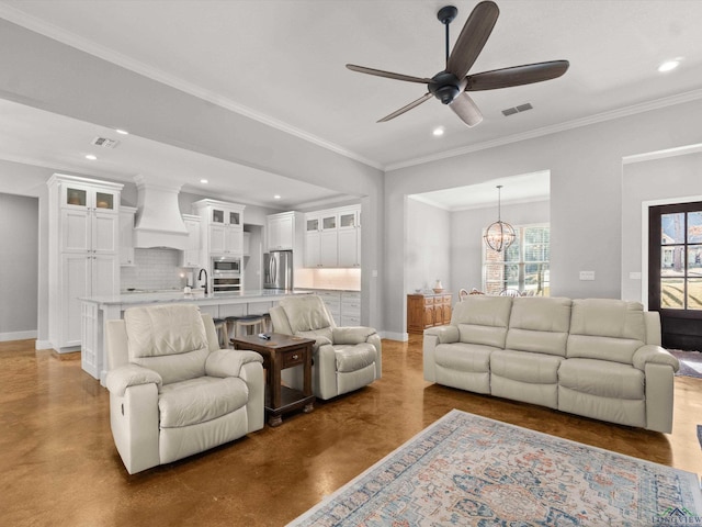 living room with sink, ceiling fan with notable chandelier, and ornamental molding