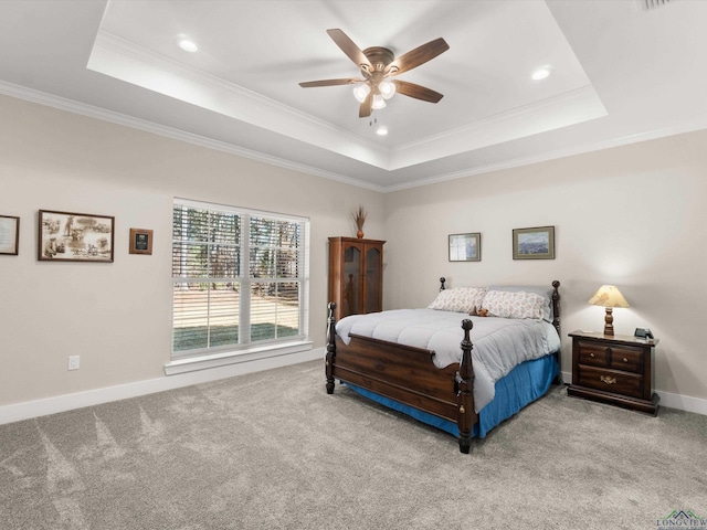 carpeted bedroom with ceiling fan, a raised ceiling, and ornamental molding