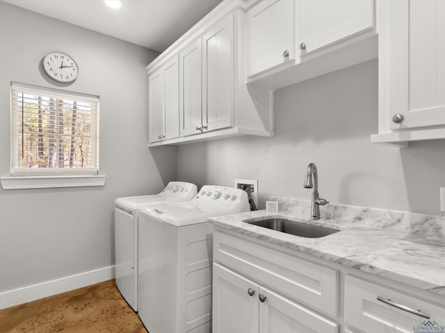 laundry room with sink, washing machine and dryer, and cabinets