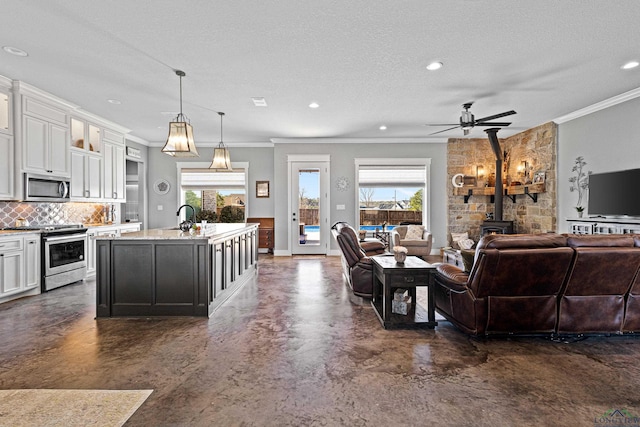 interior space with concrete floors, a wood stove, plenty of natural light, and a textured ceiling