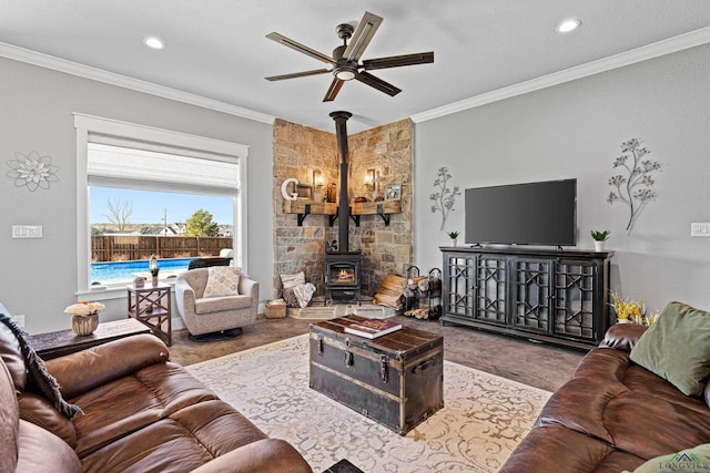 living area with a wood stove, ceiling fan, crown molding, and recessed lighting