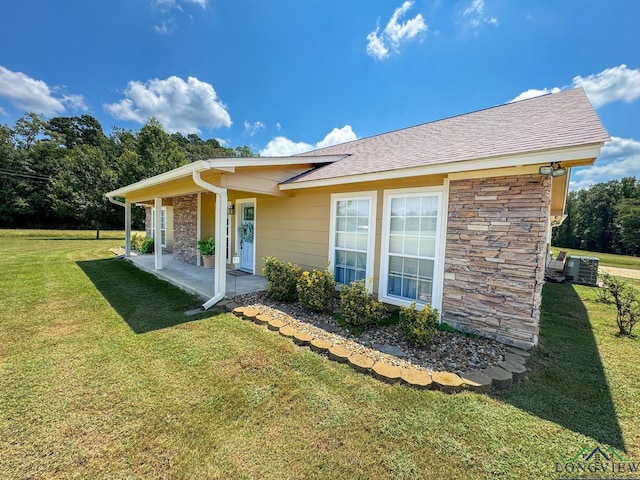 rear view of house with a yard and central AC