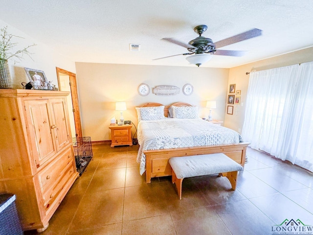 bedroom featuring tile patterned floors, ceiling fan, and a textured ceiling