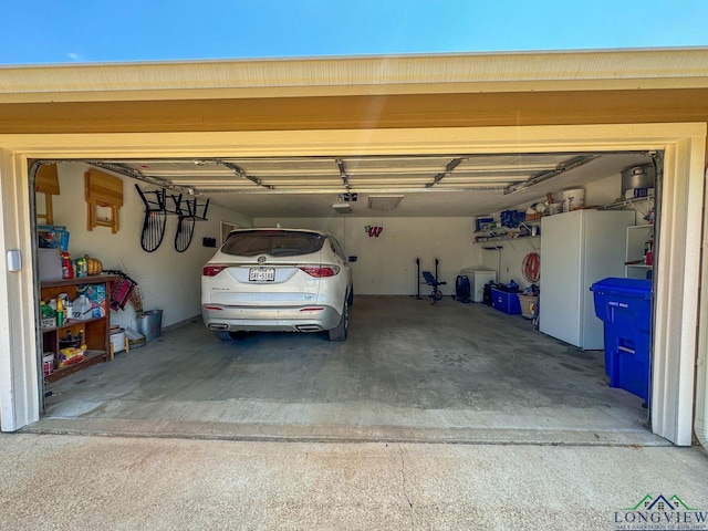 garage with white refrigerator and a garage door opener