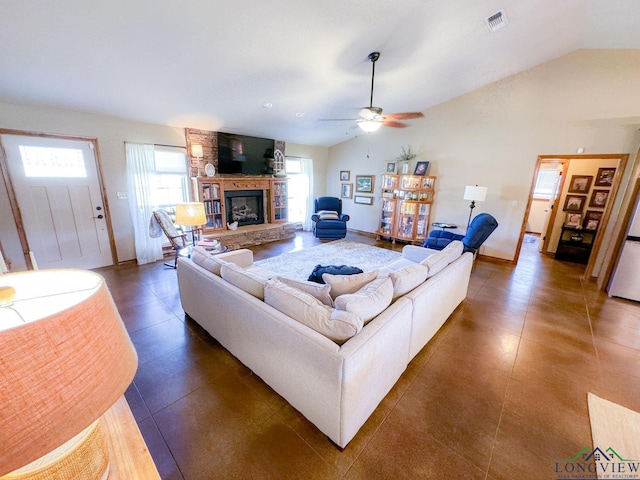 living room with ceiling fan, a fireplace, and vaulted ceiling