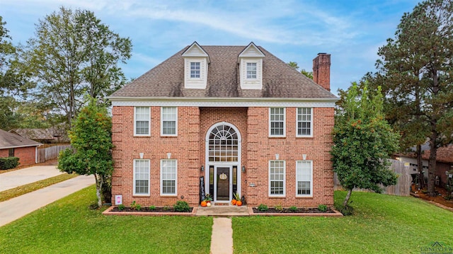 colonial-style house featuring a front yard