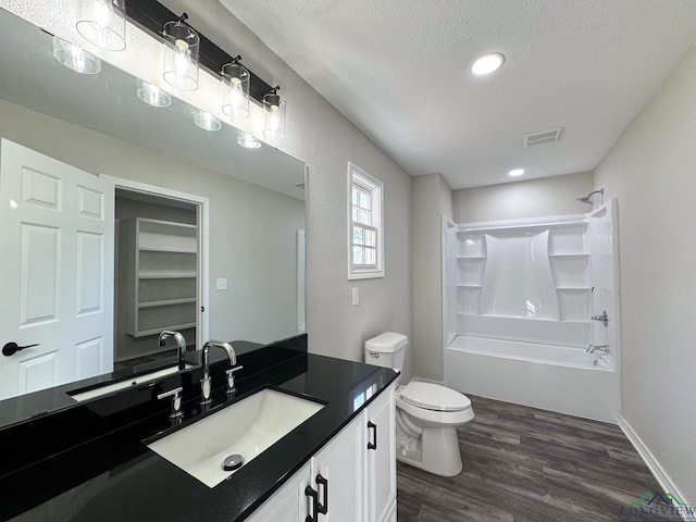 full bathroom with toilet, a textured ceiling, shower / bathtub combination, vanity, and hardwood / wood-style flooring