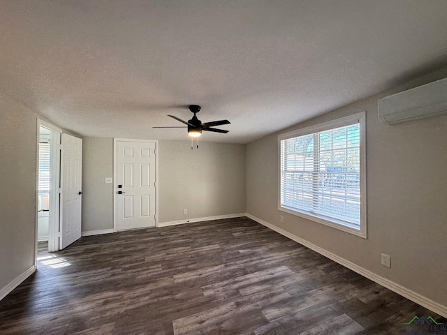 unfurnished room with dark hardwood / wood-style flooring, a textured ceiling, and a wall mounted AC