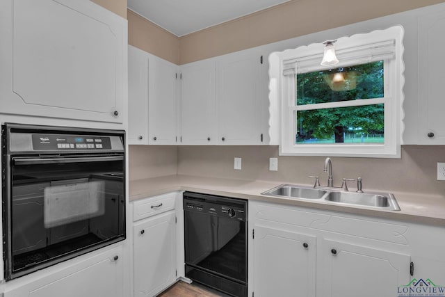 4202 Brent Rd, Longview, TX 75604 - kitchen with black appliances, a sink, light countertops, and white cabinets