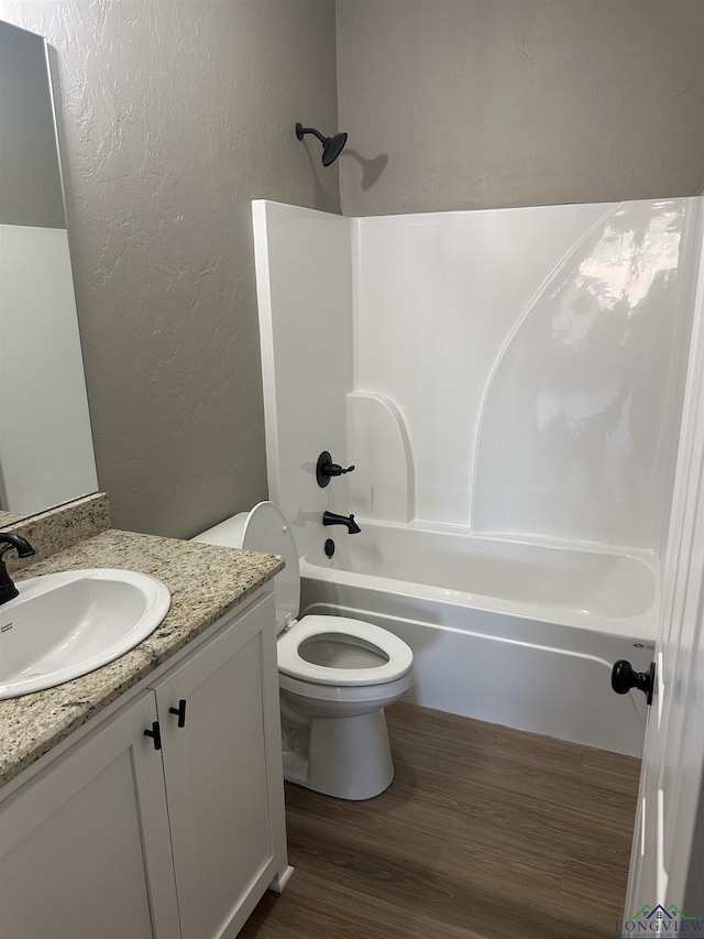 full bathroom featuring hardwood / wood-style floors, vanity, toilet, and bathtub / shower combination