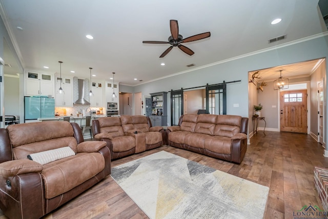 10740 Fm 2685, Gladewater, TX 75647 - living room featuring a barn door, crown molding, hardwood / wood-style floors, ceiling fan, and baseboards