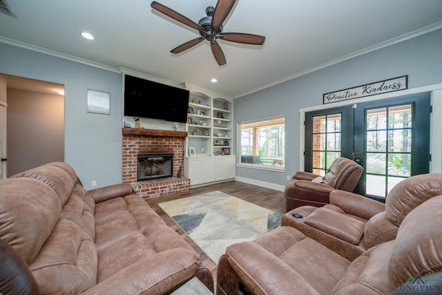 10740 Fm 2685, Gladewater, TX 75647 - living area featuring dark wood-style floors, a ceiling fan, baseboards, crown molding, and a brick fireplace