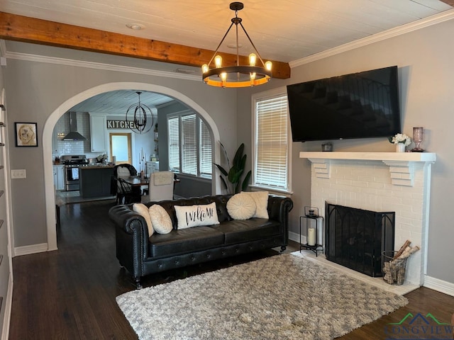 living area featuring a brick fireplace, an inviting chandelier, wood finished floors, and crown molding