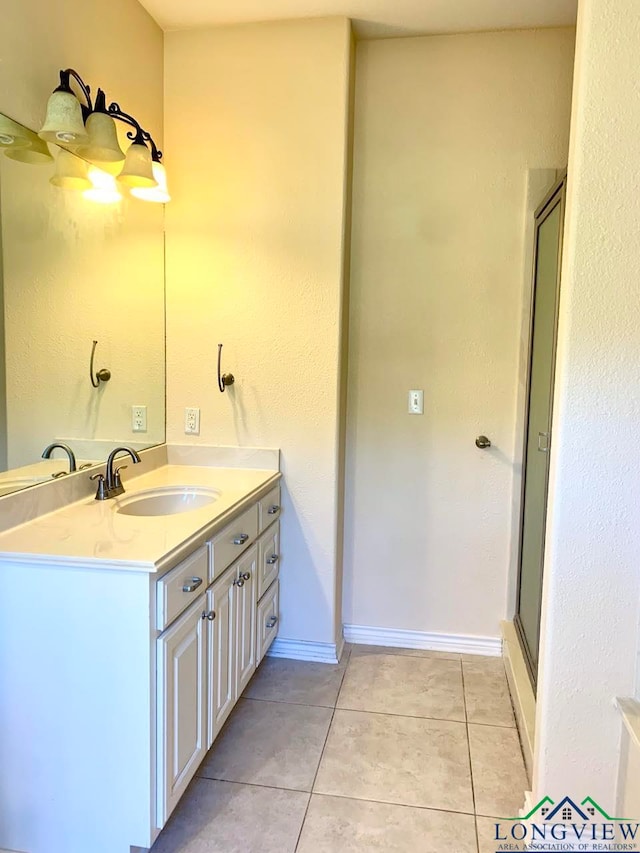 bathroom with tile patterned flooring, vanity, and a shower with door