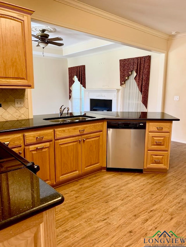 kitchen featuring dishwasher, sink, tasteful backsplash, kitchen peninsula, and light wood-type flooring