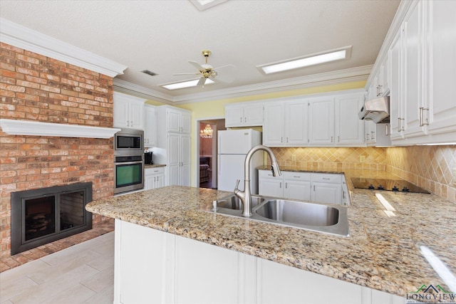 3314 Storey Lk, Tyler, TX 75707 - kitchen with a peninsula, a sink, backsplash, under cabinet range hood, and appliances with stainless steel finishes