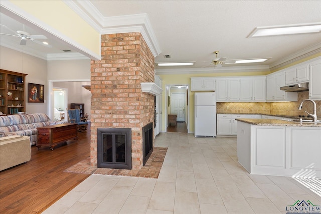 3314 Storey Lk, Tyler, TX 75707 - kitchen with ceiling fan, a fireplace, ornamental molding, and freestanding refrigerator