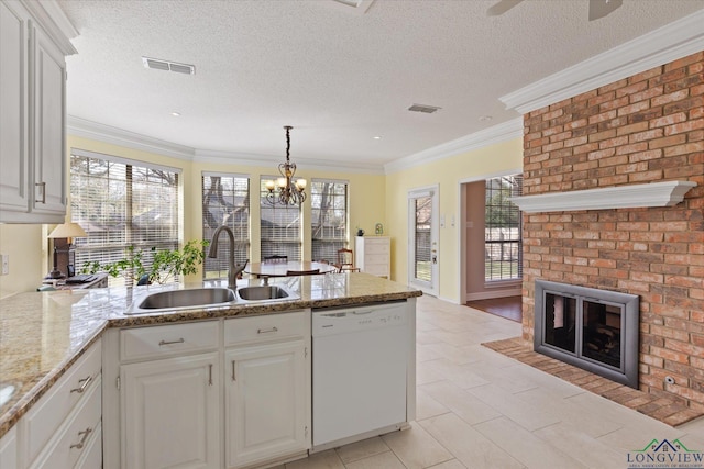 3314 Storey Lk, Tyler, TX 75707 - kitchen featuring dishwasher, visible vents, a sink, a peninsula, and a brick fireplace