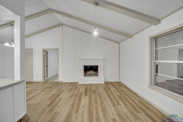 unfurnished living room featuring a chandelier, a fireplace, lofted ceiling with beams, and light wood-type flooring